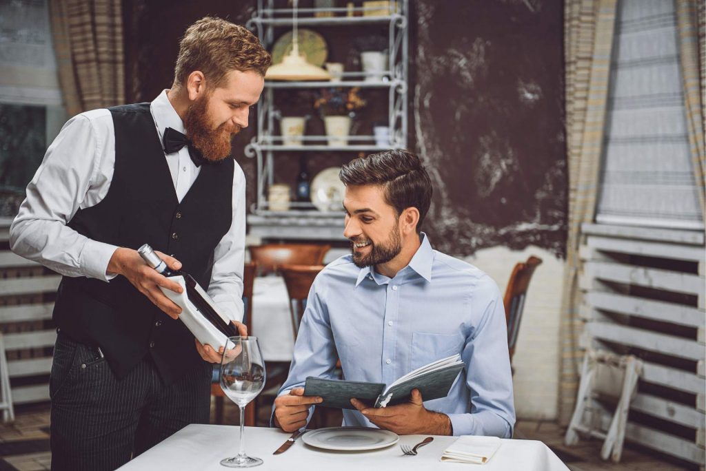 camarero-enseñando-botella-de-vino-a-cliente