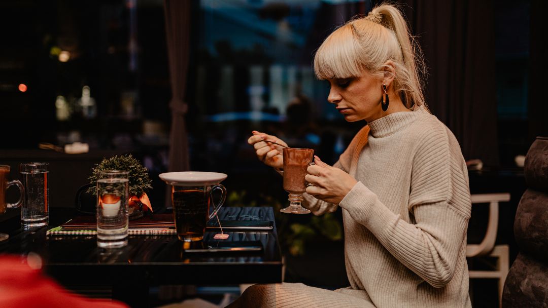 mujer tomando un chocolate caliente Historia del chocolate