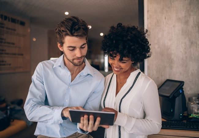 Dos personas con una tablet en un restaurante viendo información del Bono Digital para hostelería